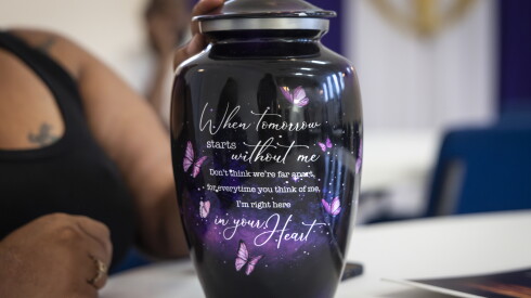 Franquella Campbell touches her mother’s urn during a community forum with attorneys and activists at Genesis Worship Ministry.