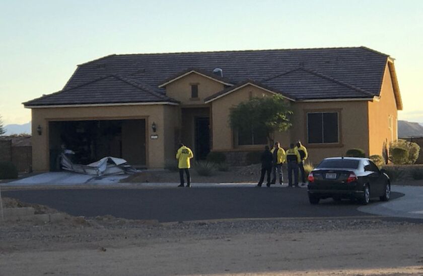 In this photo provided by the Mesquite, Nev., Police Department, police personnel stand outside the home of Stephen Paddock on Monday in Mesquite. Police identified Paddock as the gunman at a music festival Sunday evening. | Distributed by the Associated
