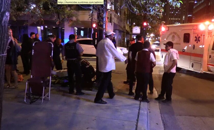 Patrons and employees of a River North nightclub look on as paramedics try to revive a woman who fainted after the two off-duty police officers she was with got into a fight outside the club early Friday. | Network Video Productions