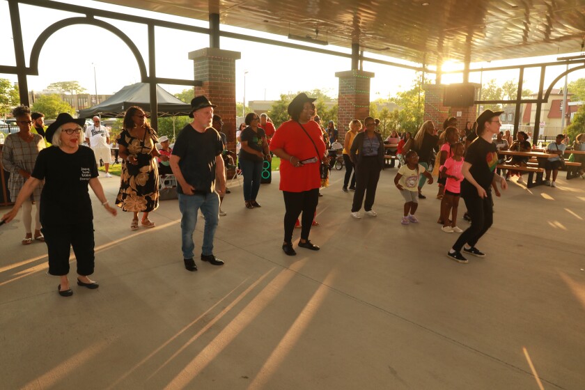 People gather for a line dance at the Village of Lansing's inaugural Juneteenth celebration on June 19, 2025.