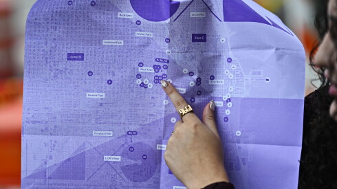 A Chicago Exhibition Week attendee points to a location on an interactive map printed for Thursday night's gallery crawls.