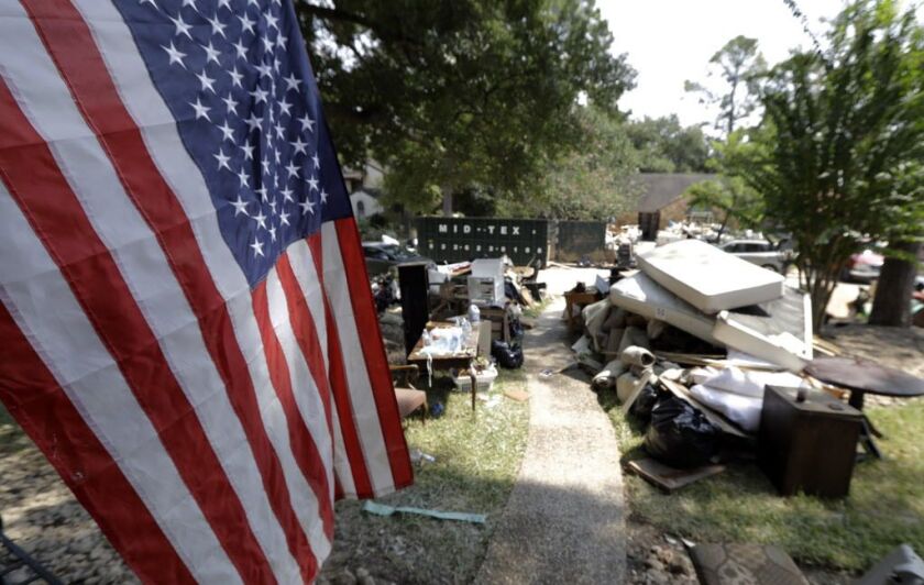 An American flag hangs outside a home damaged by floodwaters in the aftermath of Hurricane Harvey Sunday, Sept. 3, 2017, in Spring, Texas. | David J. Phillip/AP
