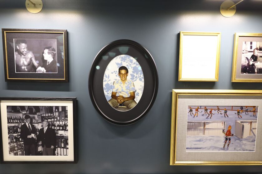 Photos of Rocky Wirtz, former owner and chairman of the Blackhawks, line the wall at the Blackhawks at the newly unveiled Rocky’s Bar in honor of Rocky Wirtz at the United Center, Tuesday, Dec. 19, 2023.