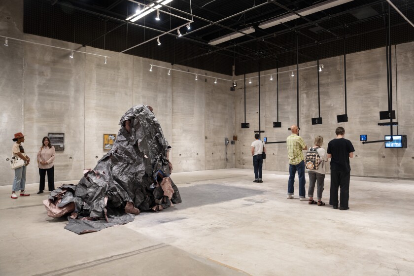 Visitors engage with “Over My Head: Encounters with Conceptual Art in a Flyover City, 1984–2015” at 400 N. Peoria St. in West Town during Chicago Exhibition Weekend, Saturday, Sept. 20, 2025. Tony Lewis' reshaped floor drawings, "Untitled 5 (2015-), 2025" and "Untitled 8 (2016-), 2025" are pictured on the left.