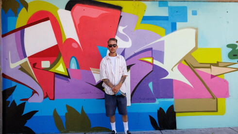 Jordan Nickel stands next to his work on a graffiti wall on Green Bay Road in Evanston.