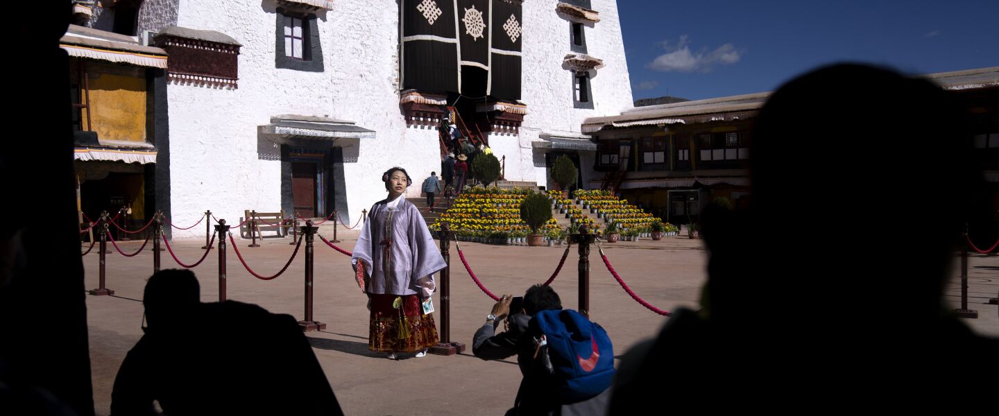 A Chinese tourist in Tibetan dress poses for a photo in a courtyard at the Potala Palace in Lhasa in western China’s Tibet Autonomous Region.