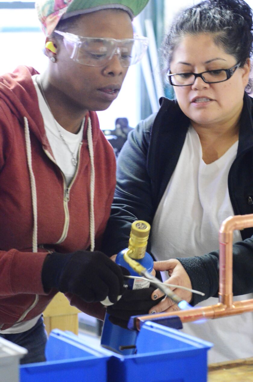<small><strong>Journeyman plumber Cristina Barillas (right) teaches student Dewanna Smalley at the Chicago Woman in Trades workshop.</strong></small>
