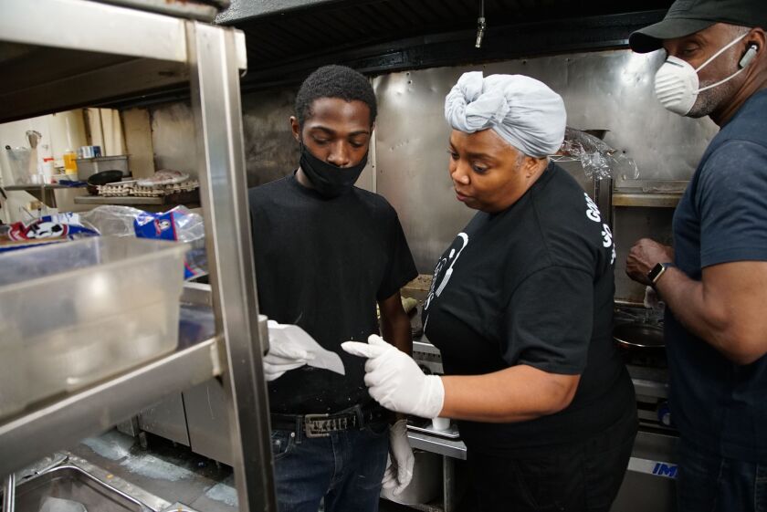Constance Simms-Kincaid goes over takeout orders with employees at 5 Loaves Eatery on Friday, May 22, 2020.