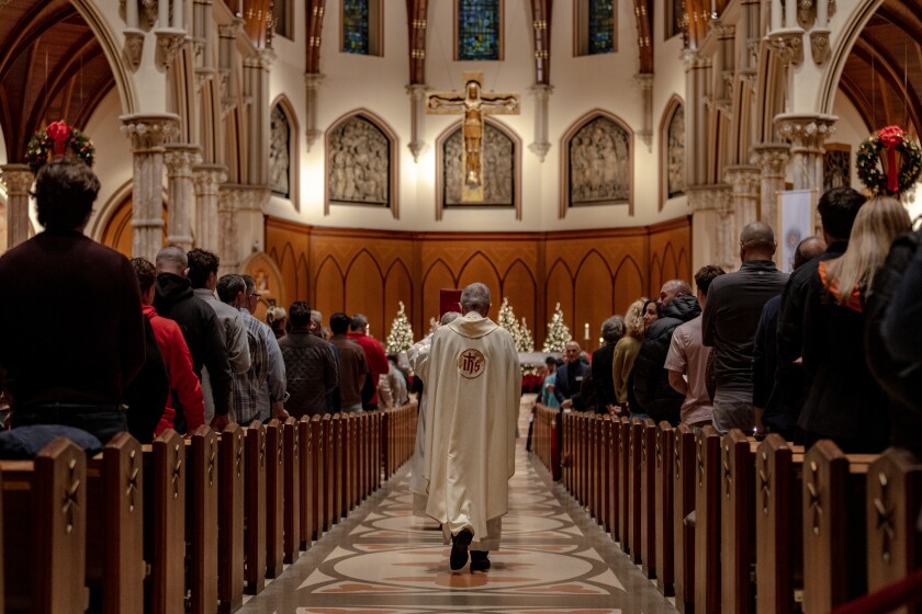 A priest makes his way to the altar during Sunday Mass at Holy Name Cathedral on Sunday December 28, 2025.