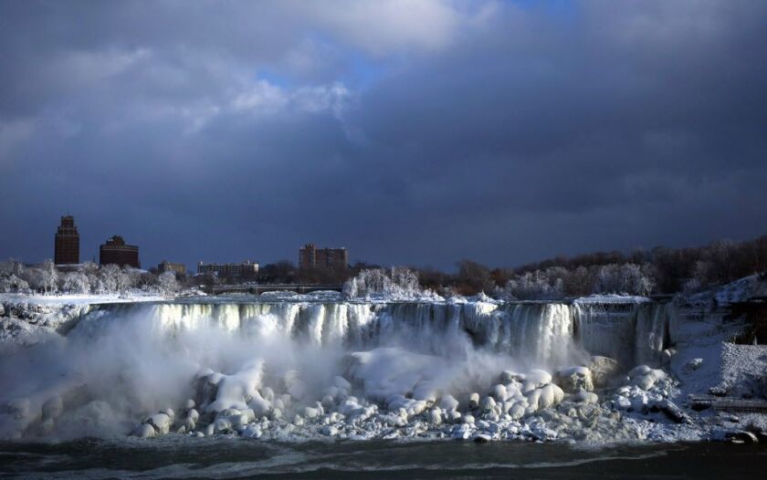 Water flows over the American Falls as ice forms in this view from the Canadian side in Niagara Falls, Ont., Tuesday, Jan. 2, 2018. Almost every year frigid temperatures transform the falls into an icy winter wonderland when the mist is blown back, freezi