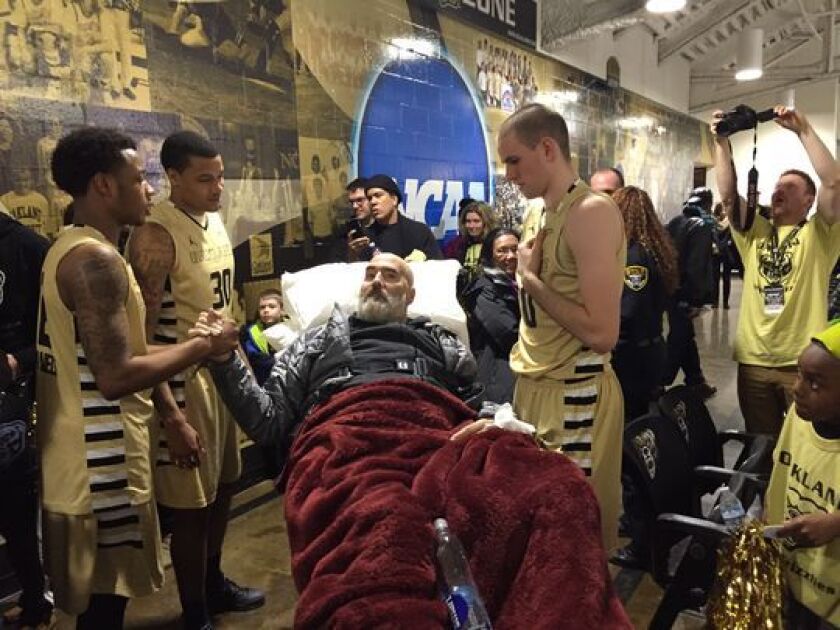 Max Hooper, right, and Golden Grizzlies teammates huddle last month around Hooper’s dad, Chip, who watched from a hospital gurney in Rochester, Mich. to see his son play against the Detroit Titans. (Photo: Mark Snyder/Detroit Free Press)