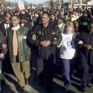 Rev. Jesse Jackson, center, and Rep. Bobby Rush, D-Ill., left, lead a chanting group of some 2,000 people through the streets of Decatur, Ill., Sunday, Nov. 14, 1999, in support of seven expelled high school students. The students, now dubbed the Decatur Seven, were conditionally expelled for two years after allegedly taking part in a brawl at a football game.