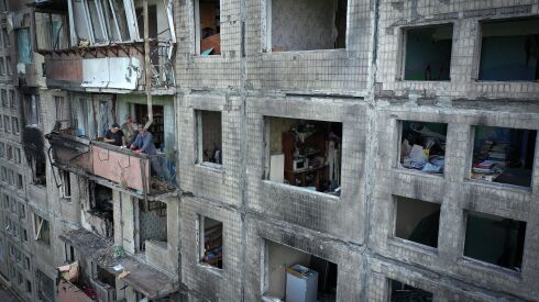 Workers begin to remove debris from a Kyiv apartment block the was hit by a Russian missile in March.
