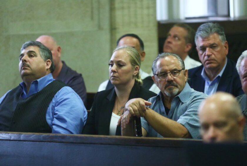 Tiffany Van Dyke, center, sits with Chicago Fraternal Order of Police President Kevin Graham, left of Van Dyke, and former Chicago Fraternal Order of Police President Dean Angelo, right of Van Dyke, during a pretrial hearing for her husband, Chicago polic