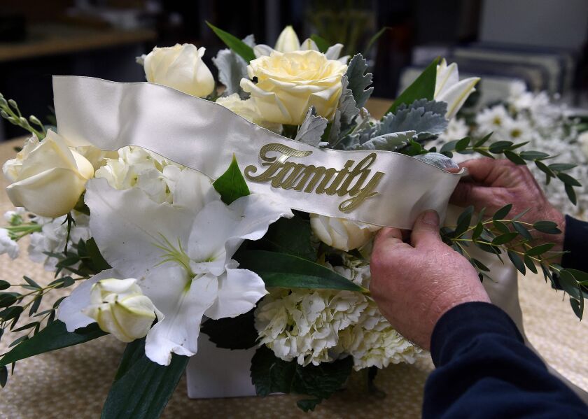 A florist demonstrates how to make floral arrangement for a funeral, amid the coronavirus pandemic at a floral shop in Arlington, Virginia on Monday.