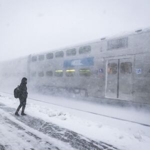 A Metra train flies by waiting commuters at the Naperville Station. | Rich Hein/Sun-Times