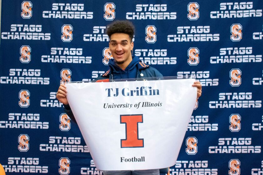 Stagg’s TJ Griffin holds up a banner to show his commitment to play football for Illinois.