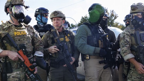 Commander-at-large of the U.S. Border Patrol Gregory Bovino stands with federal immigration enforcement agents in Little Village last week.