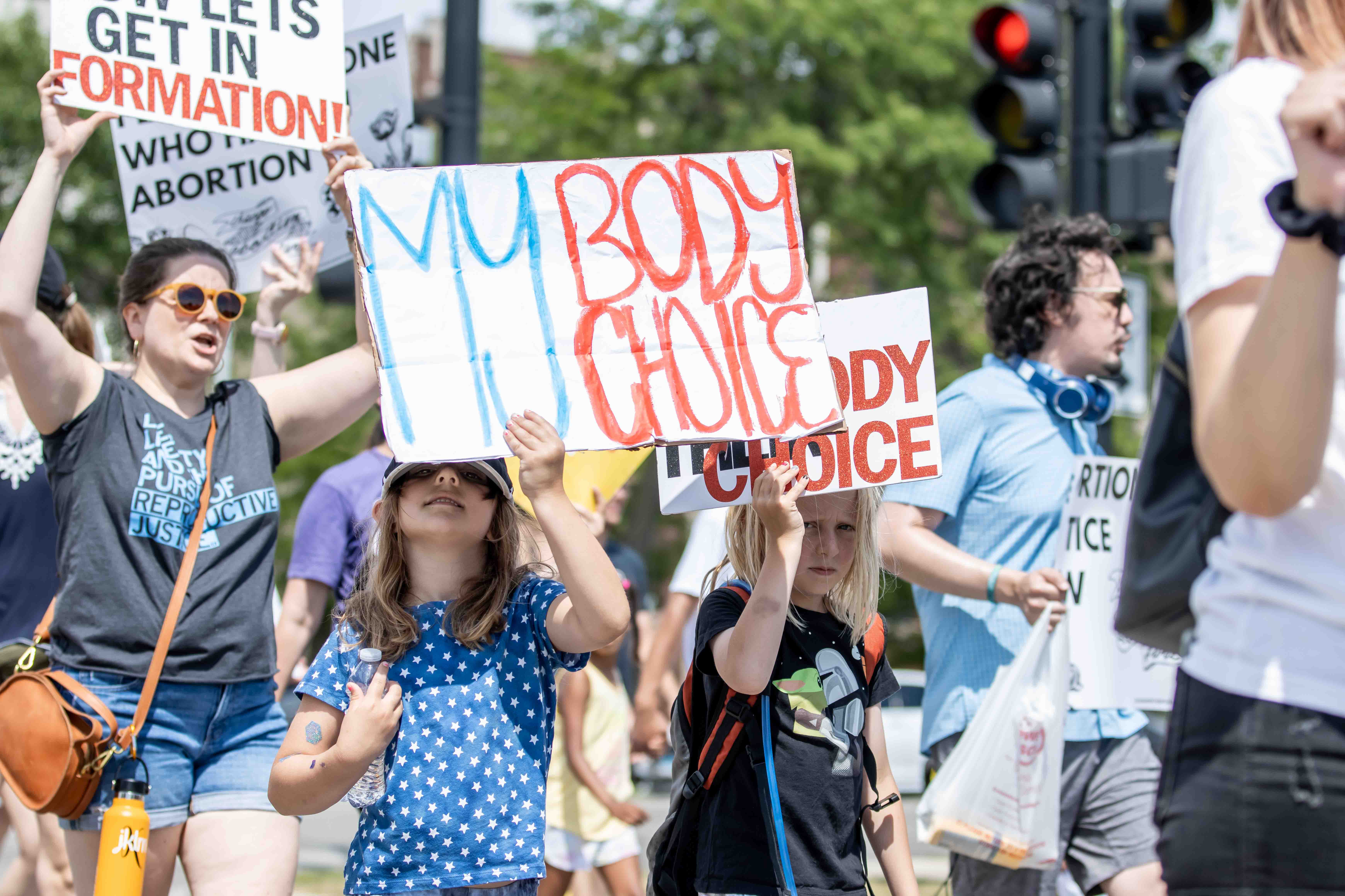 A young girl holds a sign reading "My body, my choice" in a crowd at an abortion protest in Bronzeville on July 4, 2022.